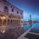 The illuminated Gothic facade of the Doge's Palace and St. Mark's Square at twilight in Venice, Italy